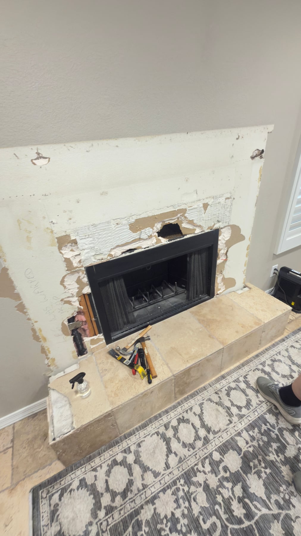 Floor-to-ceiling stacked stone fireplace remodel with wood mantel and tile hearth