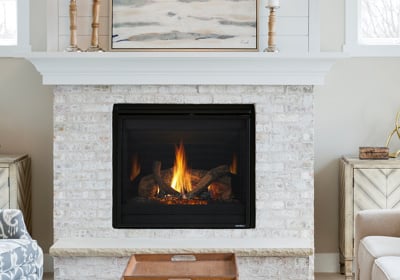 Modern gas fireplace with log set installed in white brick surround with white mantel
